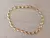 PULSERA DE ACERO ESLABÓN DORADO CONECTOR OVAL/SEMILLA. LARGO 18,5 CM