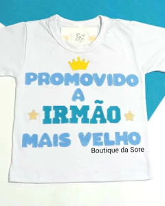 Camisa infantil branca com a frase "Promovido a Irmão Mais Velho" em letras coloridas e uma coroa amarela acima do texto.
