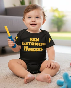 Bebê sentado vestindo body preto com texto amarelo "Ben Eletricista 11 meses" segurando uma chave de fenda de brinquedo