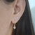 Brinco de argolinha fechada com pingente de coração folheado a ouro 18k