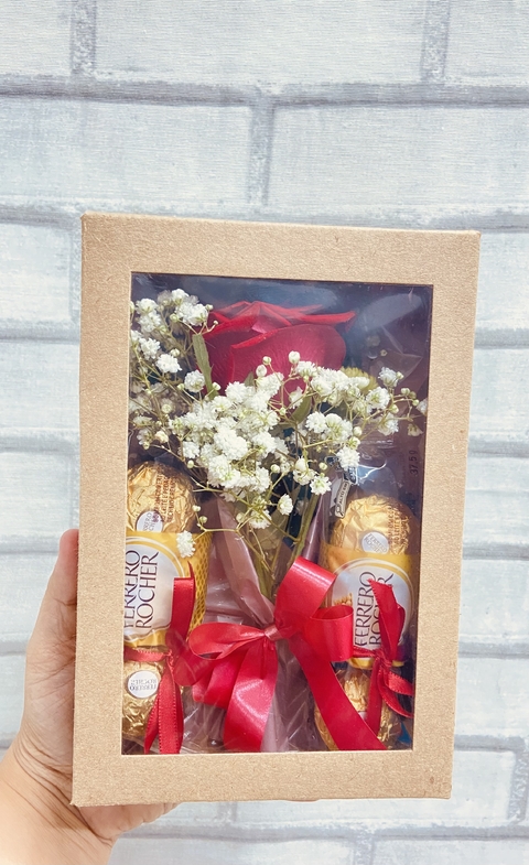 Caixa Kraft com uma rosa embalada e dois pacotes de Ferrero