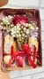 Caixa Kraft com uma rosa embalada e dois pacotes de Ferrero na internet