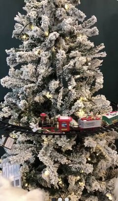 Detalhe locomotiva trem natalino vermelho com trilhos em árvore nevada decoração Natal