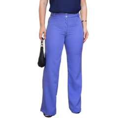 Mulher usando calça azul clara, segurando uma bolsa preta, com blusa escura.