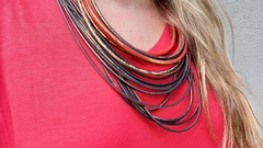 Collar PVC de tubos negros metalizado en rojo y dorado.