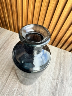 Botellón de vidrio negro con boca ancha, ideal para decoración de interiores.
