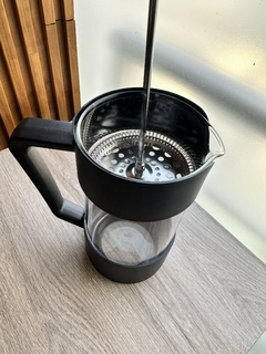 Cafetera de diseño moderno en color negro con parte de vidrio, ideal para preparar café y té.