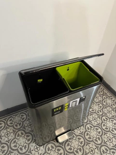 Tacho de basura dual reciclador de 40 litros marca EKO con compartimentos negro y verde, tapa metálica y pedal en cocina con piso de baldosas decorativas.