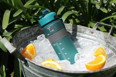 Botella motivacional 750 sports en hielo con rodajas de naranja, perfecta para mantenerte hidratado.