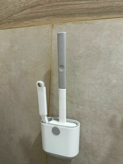 Escobilla siliconada blanca con cepillo adicional en soporte montado en pared de baño