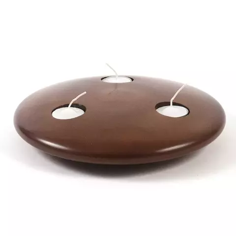 Lamparina em madeira Cedro tingido maciça torneada da Objeto Ativo tem formato que lembra um disco voador. Acompanhada de 3 velas que podem ser repostas. Sua luz suave cria uma atmosfera perfeita para momentos de relaxamento ou encontros especiais.