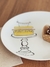 Prato de sobremesa amarelo da Coleção Delicious, com ilustração de um bolo em um suporte.