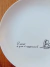 Prato raso, pintado à mão com trecho de poema do autor Fernando Pessoa e decorado com delicadas oliveiras.