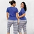 Pijama confortável de liganete com duas modelos usando blusa azul e calça estampada em zig-zag.