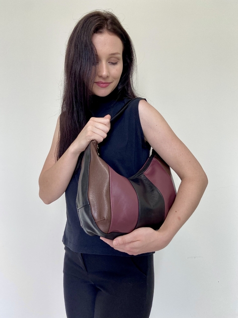 Mulher segurando a Bolsa Hobo Mia Marsala Chic, destacando suas cores e design moderno.