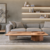 Sala de estar moderna com sofá cinza, mesa de centro de madeira e decoração minimalista.