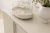 Buffet Aline de design assinado, com copos e uma garrafa decorativa sobre a superfície.