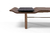 Mesa de centro Betina com tampo em mármore e design ondulado em madeira.