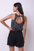 Modelo usando um cropped balonê em laise bordado preto, com detalhe nas costas e shorts pretos.
