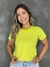 T-shirt feminina listrada na cor verde limão, apresentando uma modelo sorridente em fundo cinza.