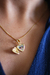 Colar relicário pequeno coração banhado a ouro 18k com foto no interior, exibido em um pescoço feminino.