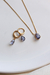 Conjunto de joias Tanzanuta Lilás com colar e brincos em gota, banhados a ouro 18k, sobre prato branco.