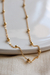 Colar Jess Bolinhas banhado a ouro 18k com detalhes em esferas metálicas, sobre um fundo claro.