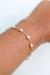 Pulseira de pérolas Alice, banhada a ouro 18k, ajustada em um pulso.