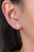 Brinco Thais Cruz cravejado, banhado a ouro 18k, com design em forma de cruz.