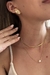 Modelo usando choker de malha fita banhado a ouro 18k, com brincos e anéis em estilo elegante.