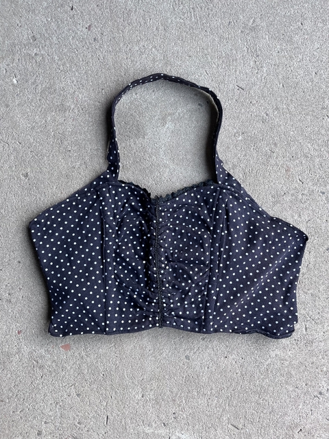 Corset negro con lunares blancos, estilo moderno y ajustado.