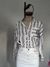 Camisa de rayas grises y blancas de Jazmín Chebar, con un bolsillo en el pecho y detalles decorativos, presentada sobre un maniquí.