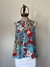 Remera sin mangas de Jazmín Chebar con estampado tropical en tonos rojos, azules y beige, exhibida en un maniquí.