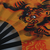 Leque de kung fu com ilustração oriental de um tigre em fundo laranja.