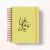 Planner amarelo com capa escrita "life goes on 2026" com espiral metálica e elástico