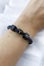 Pulseira regulável com trança de malha e berloques dos signos em opções dourado e grafite.