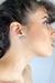 Brinco minimalista com sobreposição de triângulos equiláteros, um de plástico reciclado e o outro folheado a ouro 18k. Um acessório elegante e sustentável para complementar seu look com estilo e consciência ambiental.