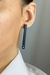 Brinco retangular minimalista preto com cristal black diamond, destacando-se com elegância e sofisticação. O detalhe do pino folheado a ouro adiciona um toque de luxo ao design moderno.