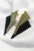 Imagem de um par de brincos triangulares com base banhada a ouro 18K e camadas sobrepostas em tons de ouro e preto. A peça grande exibe um design moderno e elegante, perfeita para adicionar sofisticação ao visual.