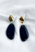 Brinco de base oval folheada a ouro 18k com pingente de cerâmica orgânico no formato de gota na cor azul escuro.