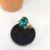 ANEL PEDRA COR ESMERALDA COM PEDRA DE CRISTAL FOLHEADO A OURO - Leila Folheados