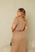 Modelo feminina usando um conjunto elegante em tom melange, com blusa de mangas curtas e saia longa, vista de costas.