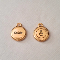 Pingente dourado com as palavras "Saúde" e um desenho de frasco químico, parte da pulseira Granada.