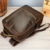 Mochila de couro marrom café para notebook de 16 polegadas com zíperes dourados e costuras específicas - design premium.