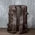 Verso da mochila de couro legítimo marrom estilo vintage, com alças acolchoadas e fivelas ajustáveis.