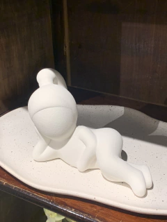 Escultura menina deitada
