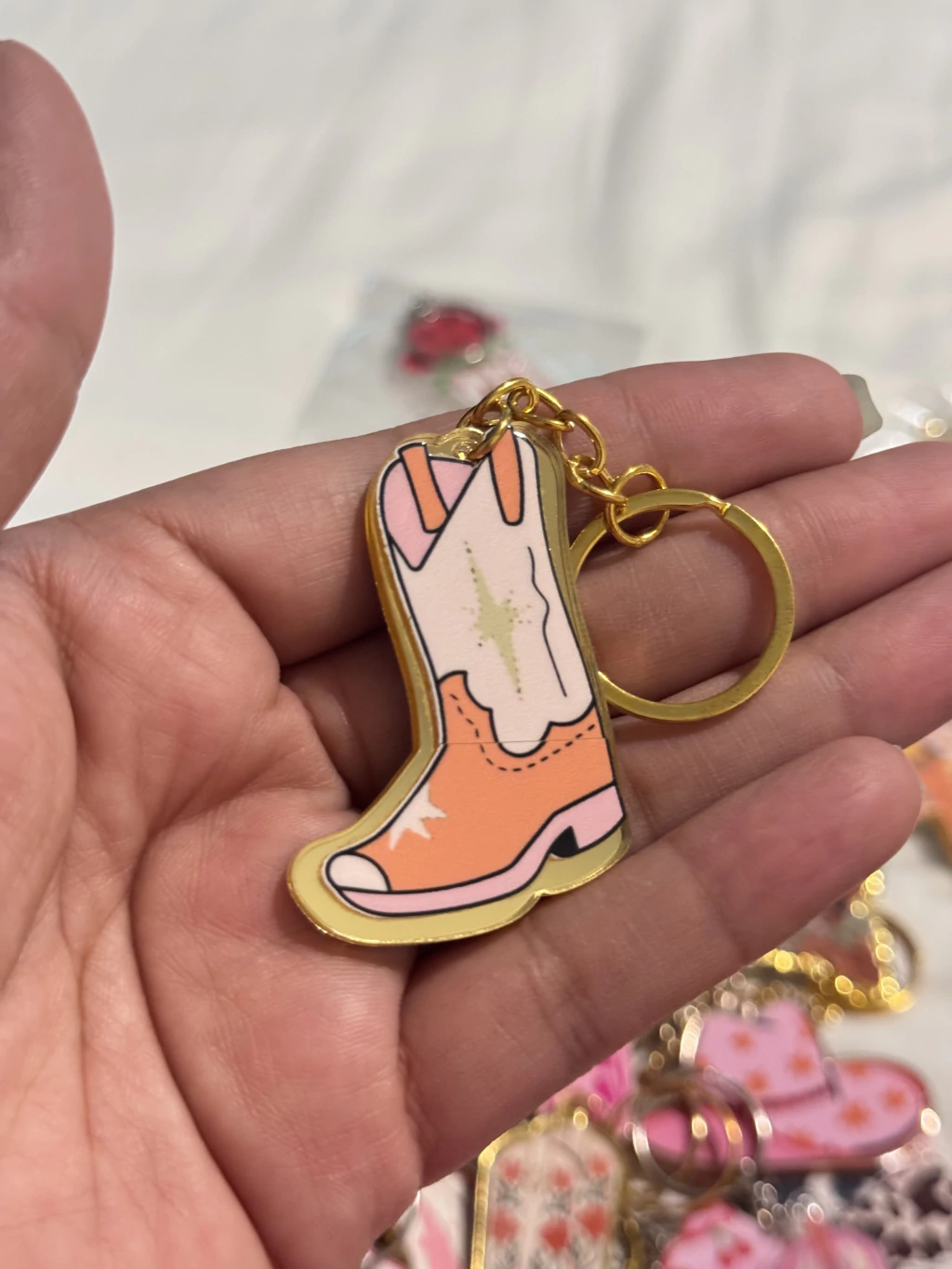 LLAVERO VAQUERO PINK MODELO CRISTAL BOTA ORANGE CON TUBO BLANCO Y ESTRELLA VERDE