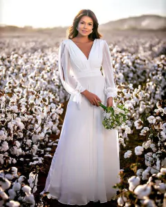 Vestido branco off longo fluido com manga longa vazada e laço.
