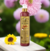 Frasco de máscara de hidratação reconstrutora Ágata Cereja e Avelã da Dolce Pet, 290 ml, em um ambiente florido.