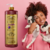 Mulher sorridente segurando dois cachorros, com embalagem de Shampoo Clareador Tonalizante Ametista Cereja e Avelã ao lado.